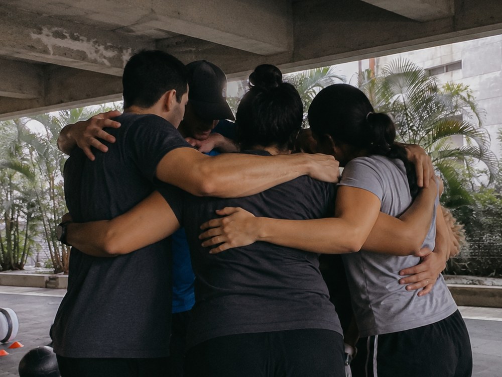 Un grupo se abraza después de entrenar.